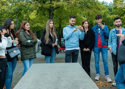 Jugendliche beim Denkmal für die ermordeten Juden Europas stehen an einer Beton-Stele