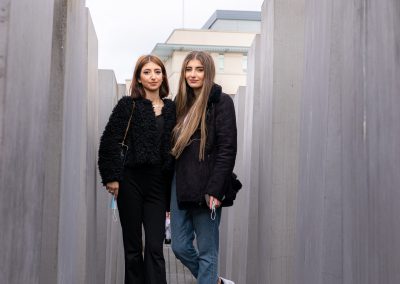 Zwei junge Frauen beim Denkmal für die ermordeten Juden Europas stehen zwischen zwei Beton-Stele