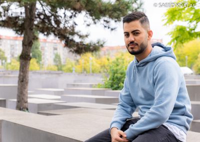 Ein junger Mann Denkmal für die ermordeten Juden Europas sitzt auf einer Stehle