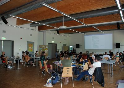 Menschen sitzen im Saal auf Stühlen